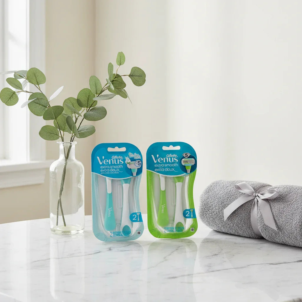 Gillette Venus Extra Smooth razors on marble vanity with eucalyptus and gray towel