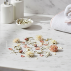 White tea leaves and petals in a serene spa bathroom setting on marble