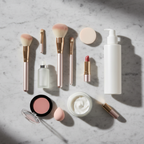 Luxury beauty vanity flatlay with skincare essentials on grey marble surface