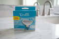 Gillette Venus Smooth 8-count refill blue box on white marble bathroom vanity in soft natural light
