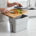 Scraping vegetable scraps into Joseph Joseph Compo 4 stone grey food waste caddy on kitchen counter – More4less Outlet