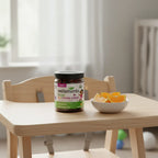 Wellements Organic Multivitamin Gummies on wooden high chair tray with fresh orange slices in ceramic bowl