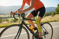 KT Tape Pro Solar Yellow kinesiology tape applied on cyclist quad muscle during outdoor ride