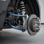 Close-up of vehicle front suspension system showing sway bar and chassis components in clean undercarriage