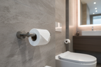Grohe Atrio SuperSteel matte toilet paper holder mounted on grey stone tile in contemporary luxury bathroom with soft ambient lighting