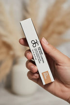 Arbonne The Real Conceal Liquid Concealer Tan in-hand close-up soft-focus professional lighting