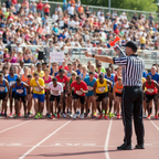 Sports event coordinator holding orange air horn signal device at running race starting line, action sports lifestyle