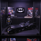 AMT 1/25 scale 1989 Batman Batmobile model kit assembled on collector shelf alongside Batman 1989 movie memorabilia with resin Batman figure