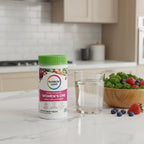 Rainbow Light Women's One Multivitamin bottle on quartz kitchen island with glass of water and bowl of organic kale and berries