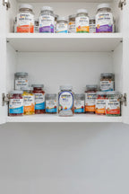 Centrum Men 50+ MultiGummies organized in white kitchen cabinet with soft lighting alongside other supplement jars