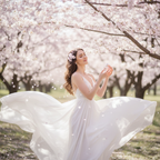 Lifestyle image - woman in white dress in blooming cherry blossom garden, serene spring lifestyle fragrance editorial for visual context only