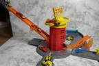 Close-up low angle of Hot Wheels City Super Fire Station red tower with yellow dome rotating and orange Speed Snap track ramp