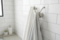 Clean bathroom aesthetic featuring brushed nickel robe hook mounted on subway tile