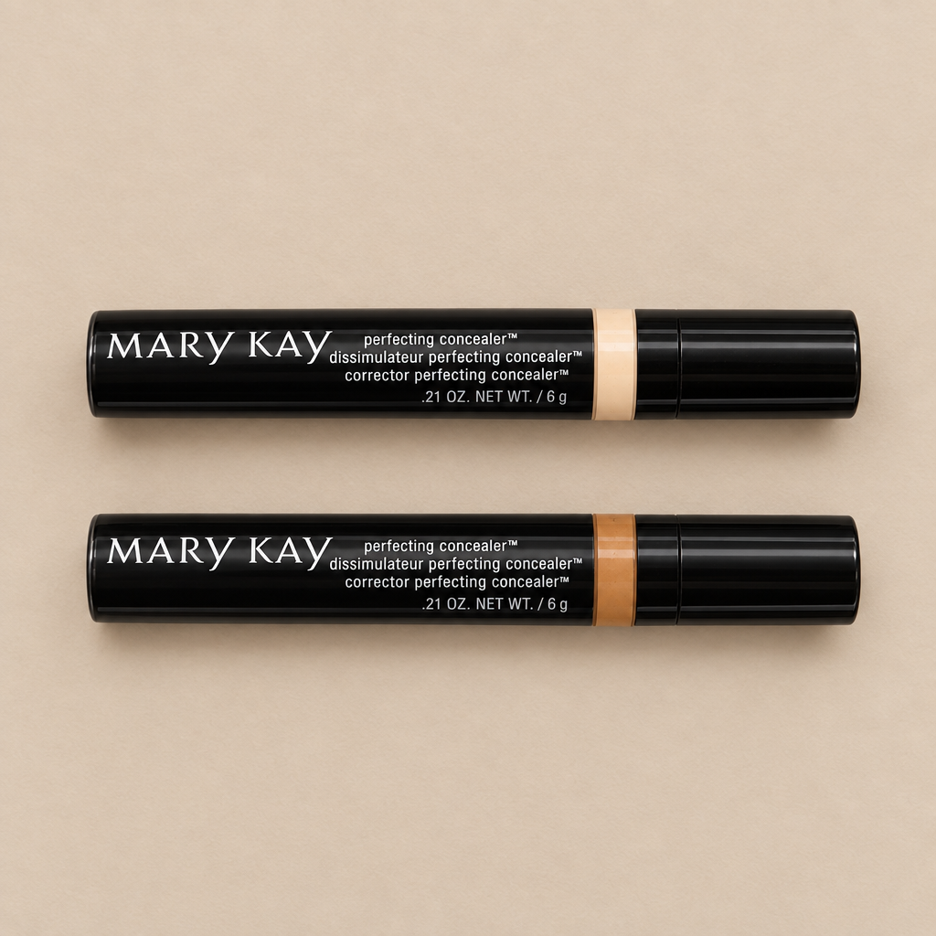 Overhead view of Mary Kay Perfecting Concealer tubes in Deep Ivory and Deep Bronze on a neutral surface