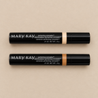 Overhead view of Mary Kay Perfecting Concealer tubes in Deep Ivory and Deep Bronze on a neutral surface