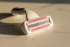 Detailed shot of a moisture-rich women's razor head with Olay gel bars in soft morning light on white marble