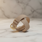 LAUT Novi Luxe beige vegan leather Apple Watch strap close-up showing ribbed texture and gold LAUT buckle