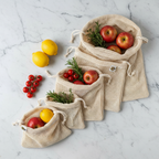 SuperBee organic cotton mesh produce bags flat lay on white marble with fresh fruits and vegetables