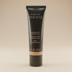 Close detail of Mary Kay TimeWise Luminous 3D Foundation tube in Ivory N 160 on a neutral background