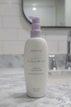 Mary Kay TimeWise Visibly Fit Body Lotion white bottle with purple pump on grey marble bathroom countertop