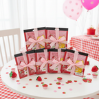 Six Strawberry Shortcake scratch and sniff sticker pads arranged as party favor gifts with pink ribbon bows on birthday party table