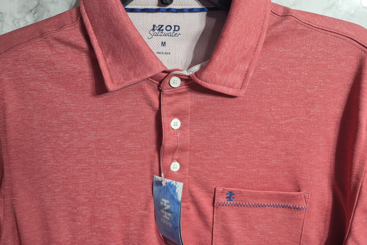 Close-up of IZOD Saltwater polo shirt chest pocket with IZOD logo embroidery and white button placket on heathered red fabric – More4less Outlet