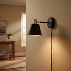 Globe Electric Lex matte black brass wall sconce on warm beige hallway wall