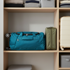 Teal blue rolling duffel collapsed flat stored neatly on closet shelf — Protégé 25-inch collapsible storage feature — More4less Outlet