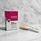Viviscal Advanced Hair Health box on marble bathroom vanity with premium ceramic hairbrush and white silk scrunchie
