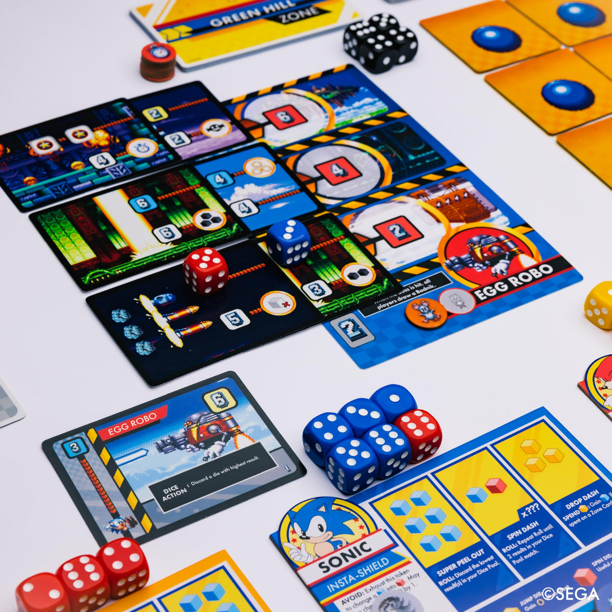 Product detail image for KESS Sonic Roll board game showing zone board, dice, cards, and tokens.