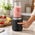 KitchenAid Go cordless personal blender making a strawberry smoothie on a dry kitchen counter