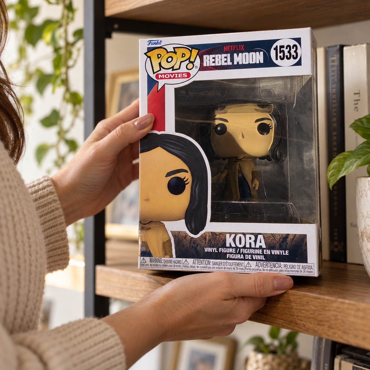Boxed Funko Pop! Kora #1533 being placed on a bookshelf.