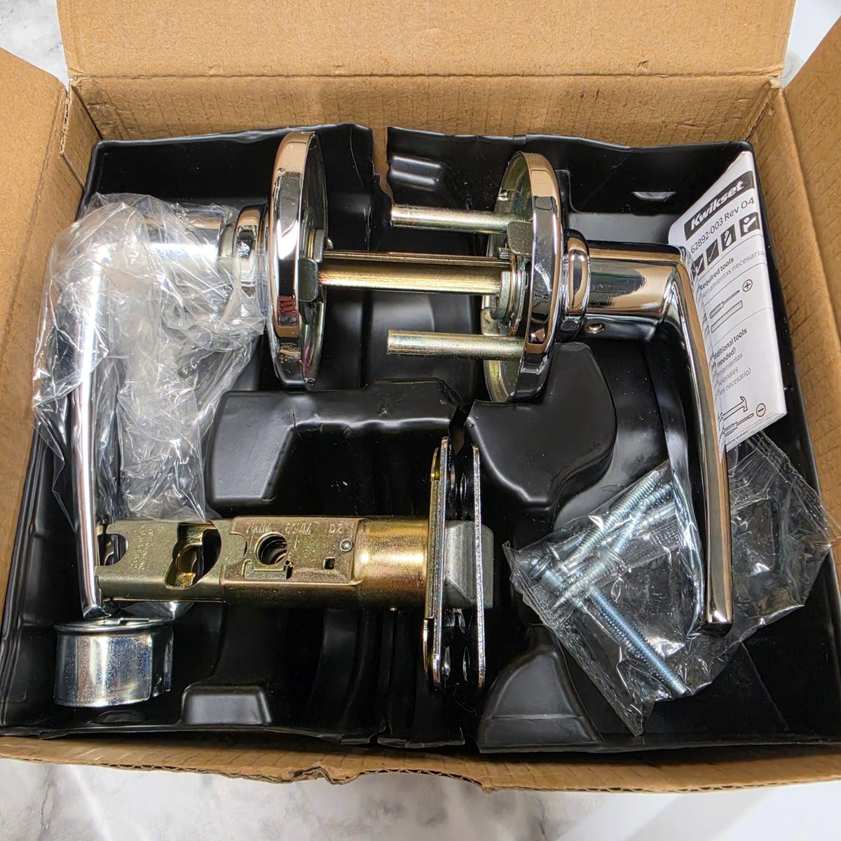 Actual Kwikset Delta 92001-533 polished chrome passage lever set in its box with latch and hardware