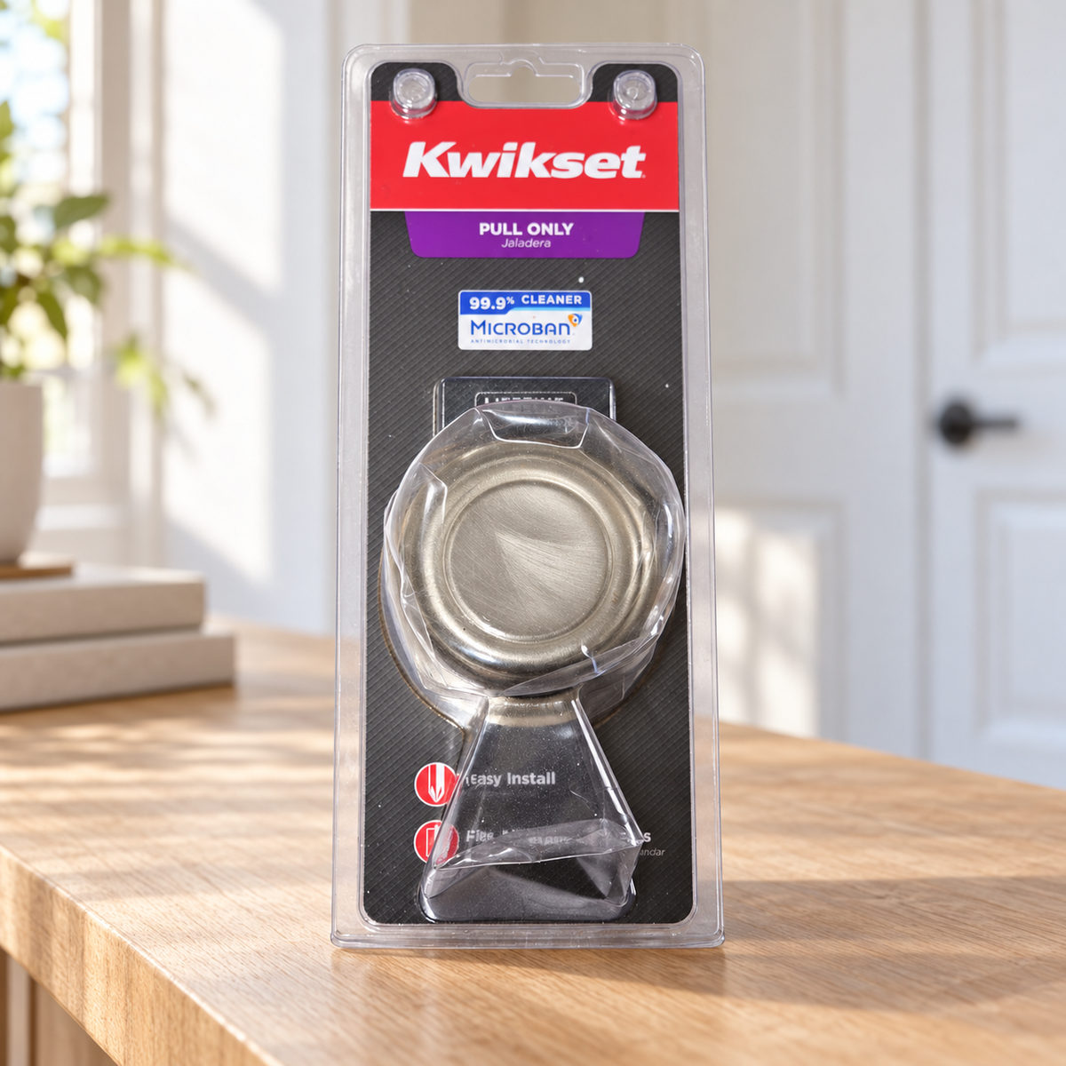 Illustrative scene of Kwikset Cameron 788CN 15 Pull-Only Door Knob, Satin Nickel in its retail package on a hallway console beside an interior door