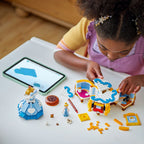 Child assembling LEGO Cinderella’s Dress 43266 beside a tablet, with the dress, display-base pieces and characters on the table