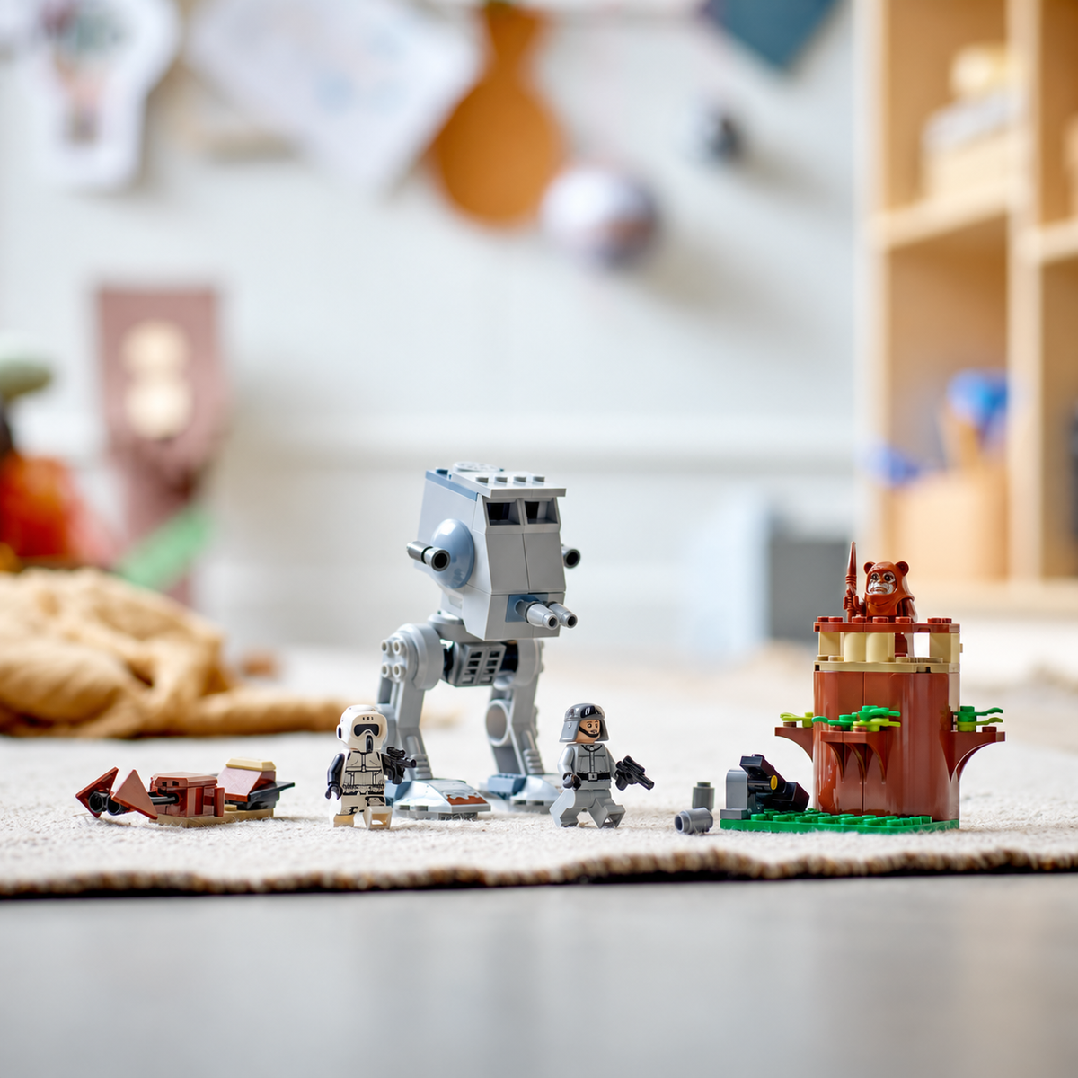Built LEGO Star Wars AT-ST 75332 set with walker, speeder, Ewok lookout and three minifigures on a play mat.