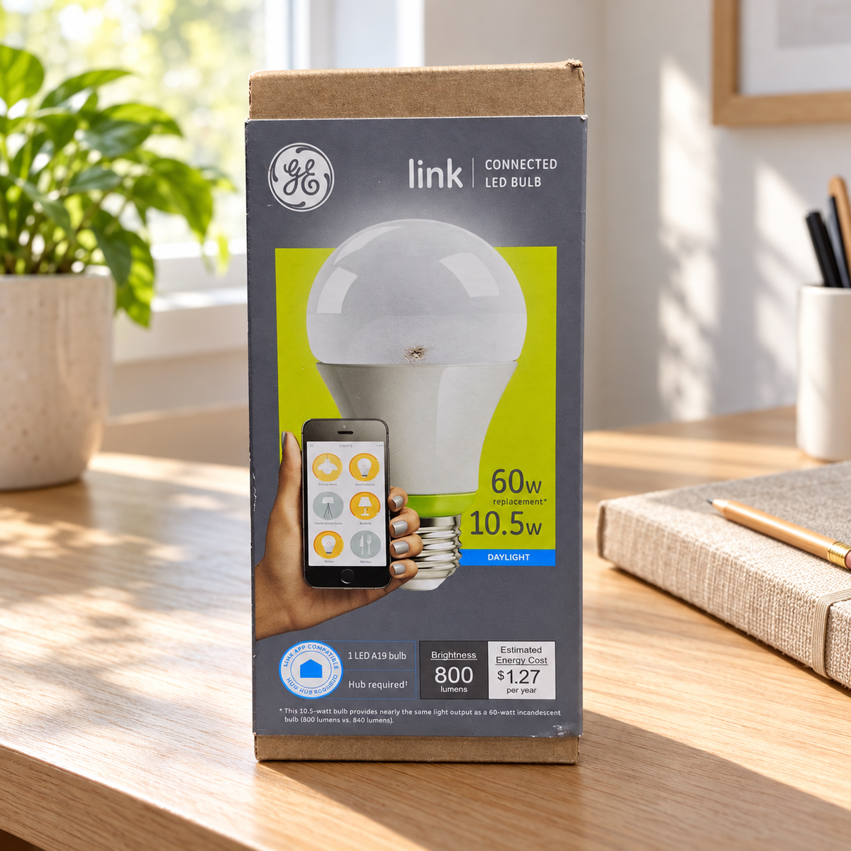 GE Link A19 daylight LED bulb carton in home office setting; AI-generated lifestyle illustration