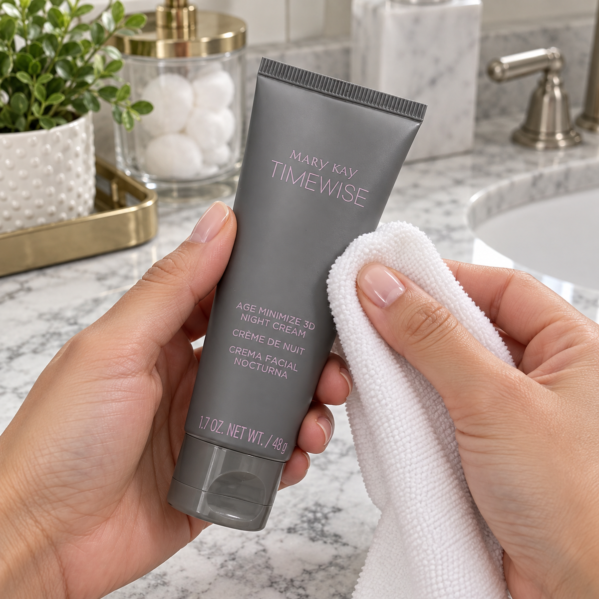 Wiping the outside of a closed Mary Kay TimeWise Night Cream tube with a soft cloth