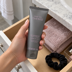 Taking a closed Mary Kay TimeWise Night Cream tube from a bathroom drawer