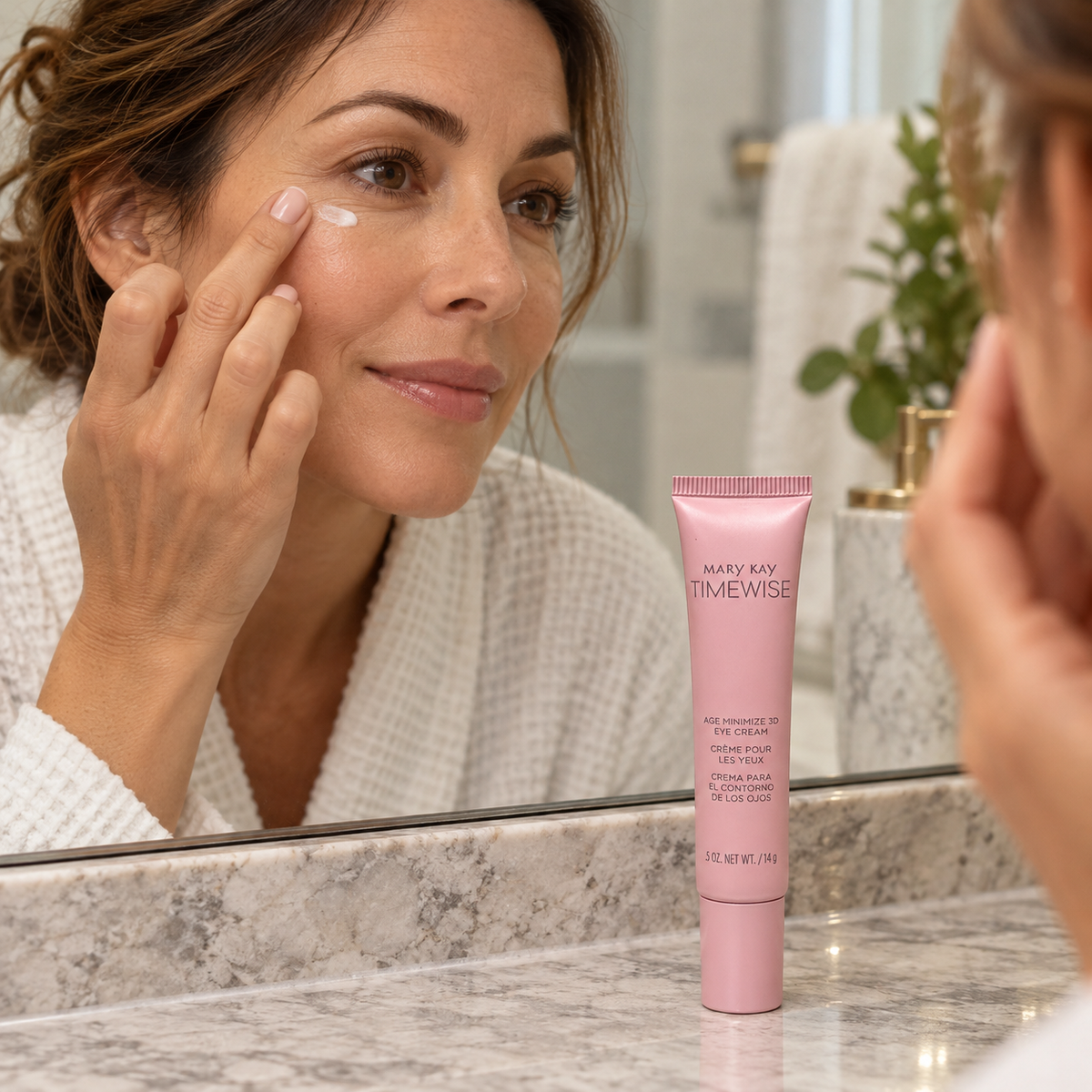 Gently patting eye cream below the eye beside a pink TimeWise Age Minimize 3D tube