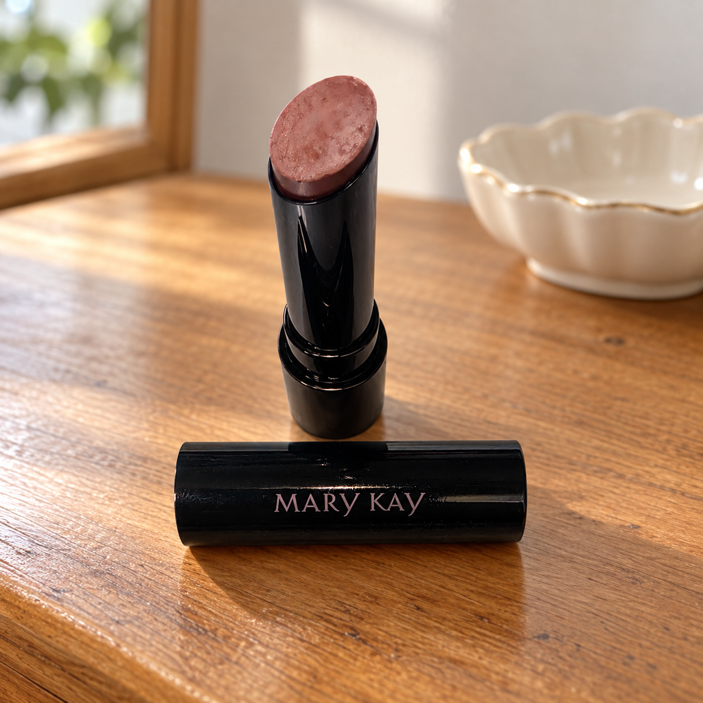 Mary Kay Better Than Bare lipstick on a wooden dresser beside a cream jewelry dish