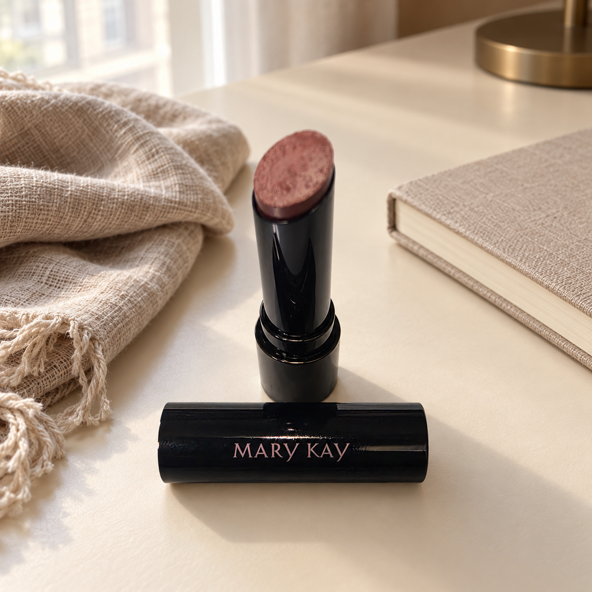 Mary Kay Better Than Bare lipstick on a cream desk beside a linen scarf and notebook