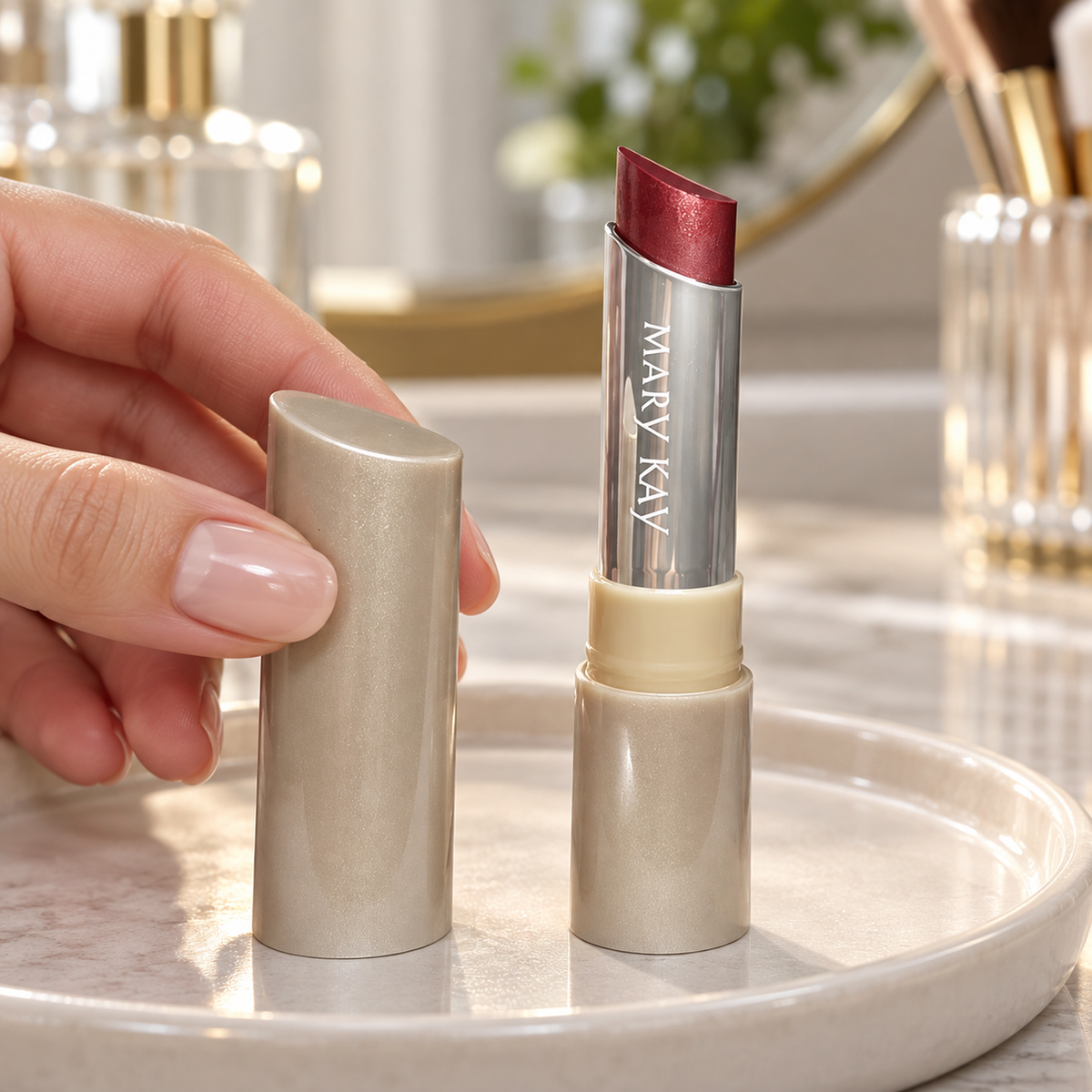 Hand lifting the cap beside an open Mary Kay City Modern Oh So Currant lip creme