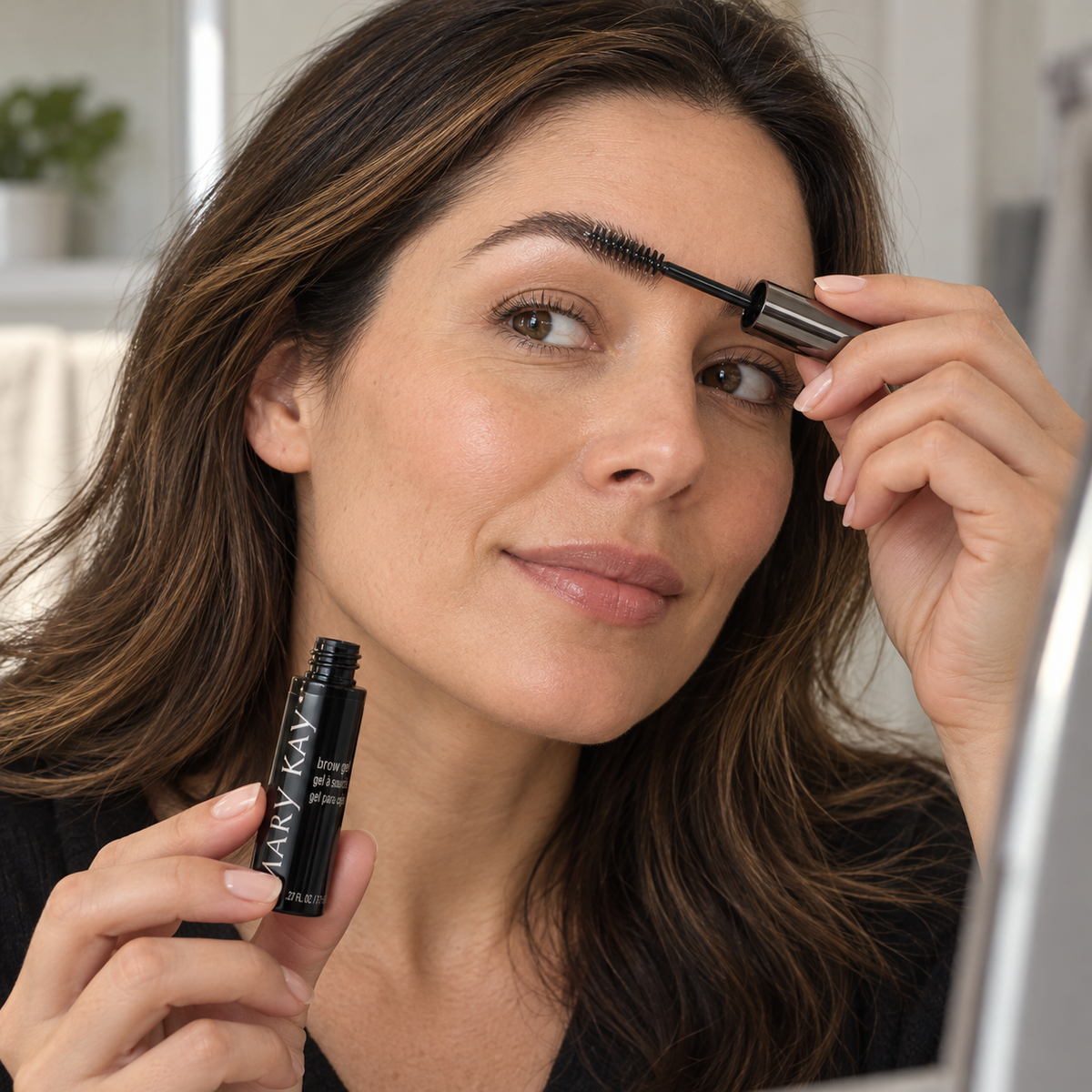 Adult brushing her eyebrow with Mary Kay Clear Brow Gel