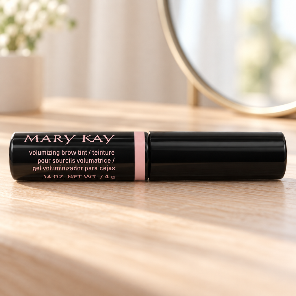Mary Kay Volumizing Brow Tint Dark Blonde on a light wood vanity beside a mirror