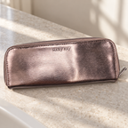 Metallic Mary Kay zippered eye brush case on a stone bathroom vanity