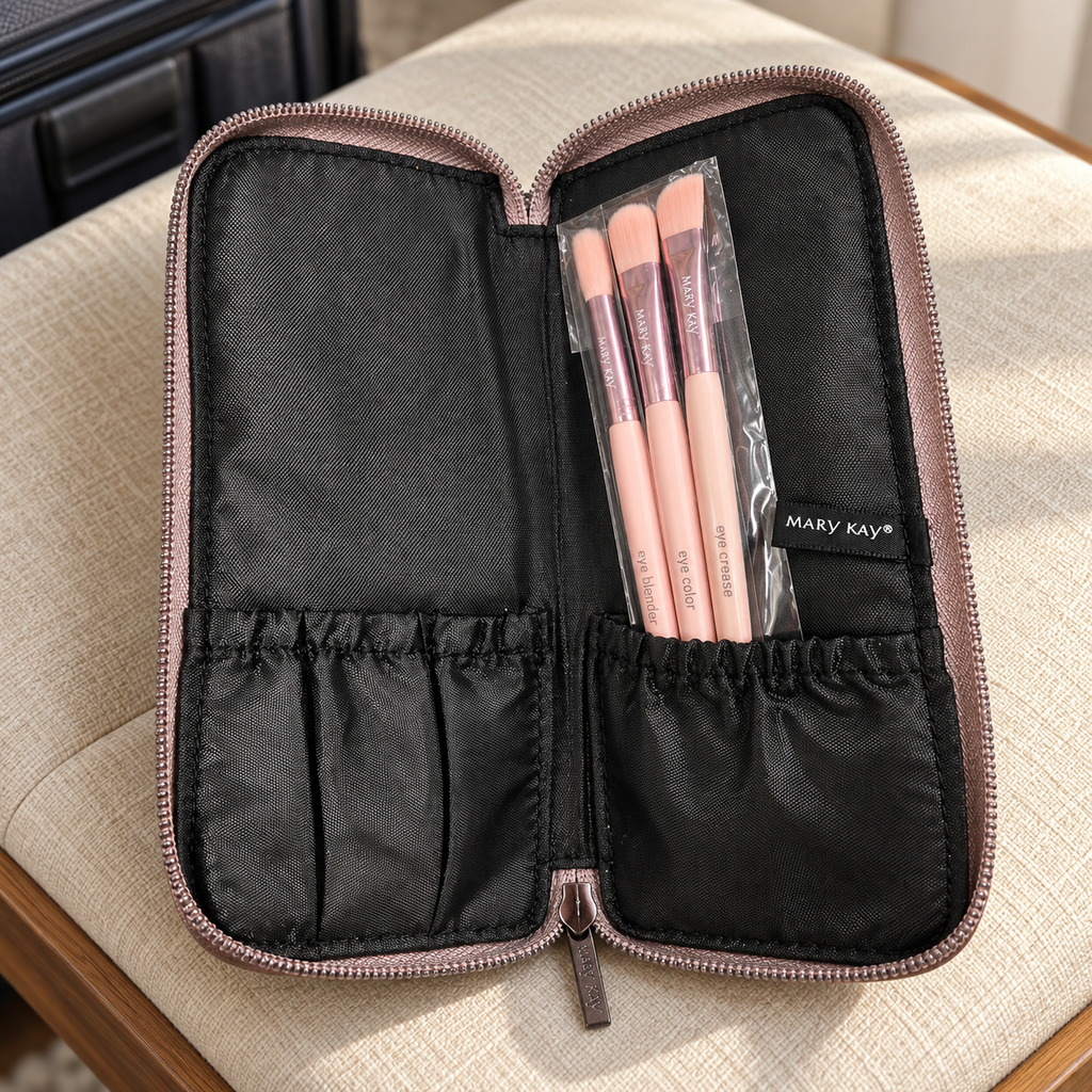 Three sleeved pink Mary Kay eye brushes in the open case on a linen travel bench