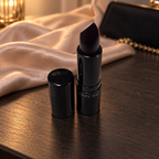Mary Kay Puro Mirtillo matte lipstick beside champagne satin and an evening clutch