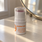 Mary Kay at Play Razzleberry lip and cheek stick standing beside a vanity mirror