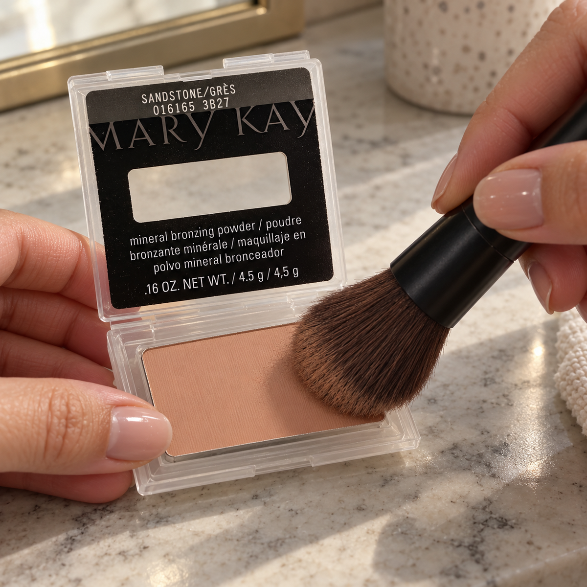Picking up Sandstone bronzing powder with a makeup brush